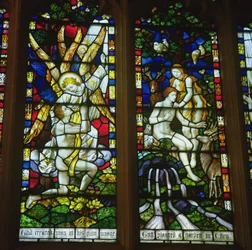 Stained glass windows depicting The Annunciation and Adam and Eve in the Garden of Eden